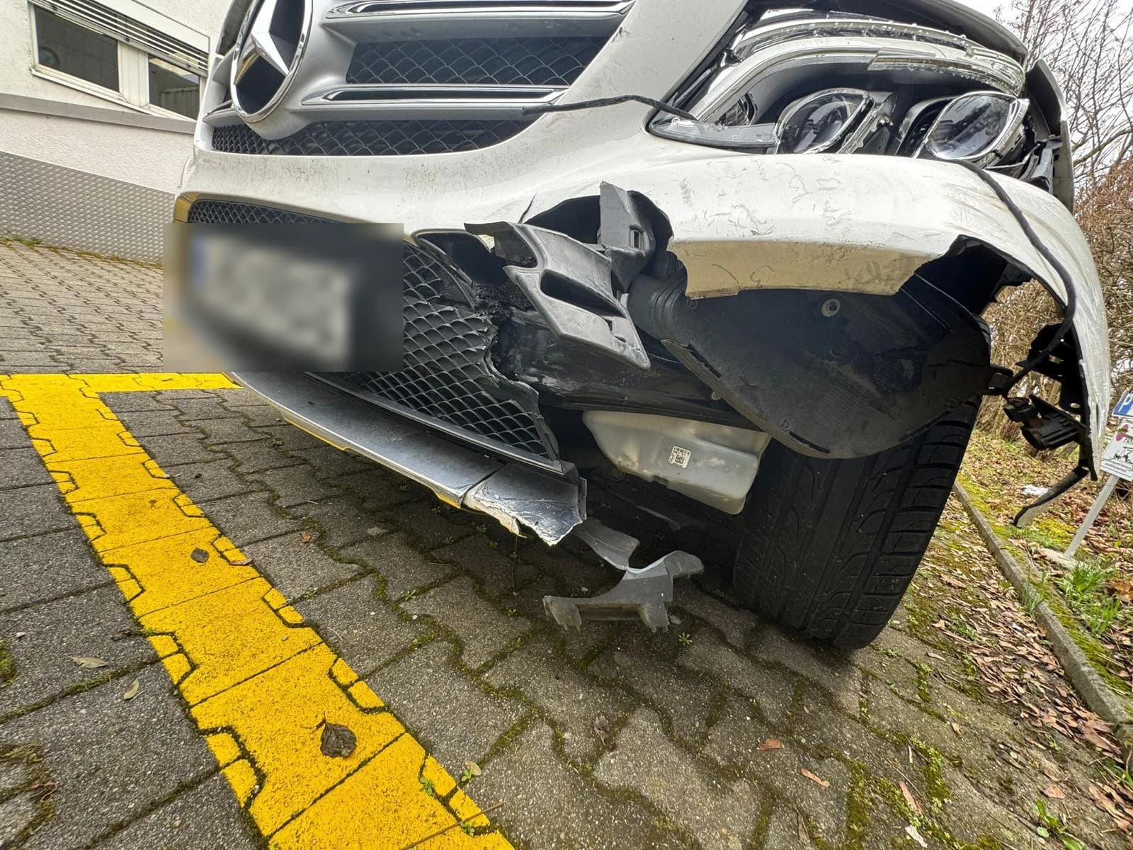 Frontschaden am Mercedes-Benz GLE — gerissener Stoßfänger und freigelegter Scheinwerfer, Beweisfoto Fall A