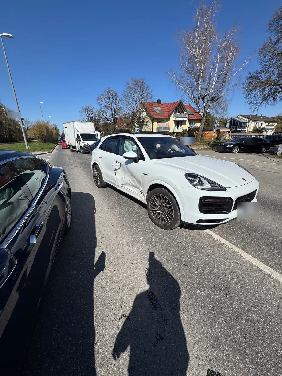 Porsche Cayenne E-Hybrid an der Unfallstelle — Fahrzeug quer auf der Fahrbahn, Seitenschaden sichtbar